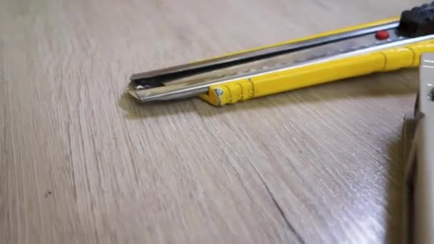 A mans hand takes a tape measure from the table. Old tools are on the table. On the table are tools for various types of construction and repair work. — Stock Video