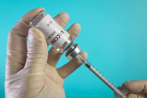Ein Arzt in weißen Handschuhen nimmt den Coronavirus-Impfstoff in eine Spritze. Coronavirus-Behandlung. Coronavirus-Impfkonzept. — Stockfoto