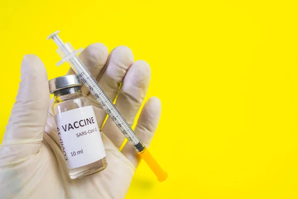 Der Coronavirus-Impfstoff und eine Insulinspritze liegen auf der Hand des Arztes. Weltweites Impfkonzept. Behandlung von Covid-19. — Stockfoto