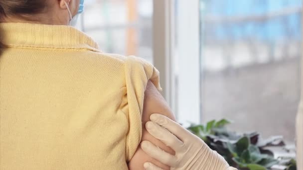 シニア女性は自宅でCOVID-19ワクチンを取得します。老人ホームでワクチン注射をする医者. — ストック動画