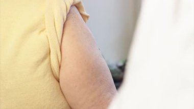 Yaşlı kadın evde COVID-19 aşısı yaptırıyor. Doktor evde yaşlı bir kadına aşı yapıyor..