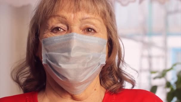 Donna anziana con una maschera medica a casa. Vaccinazione degli anziani. Prevenzione del coronavirus covid-19 in caso di pandemia. — Video Stock