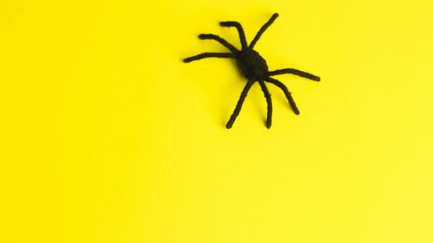 Negro araña grande corriendo sobre fondo amarillo dejando texto Feliz Halloween. — Vídeos de Stock