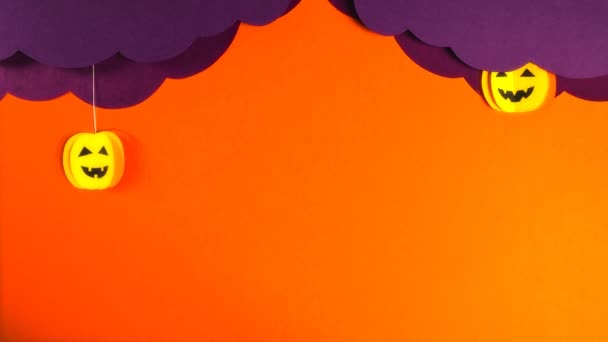 Twee pompoenen vallen uit gekrulde lila wolken. Sterren lichten op, zwarte vleermuizen vliegen. Halloween viering concept. Stop bewegingsanimatie. — Stockvideo