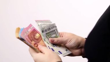 Avro paralarını sayan, siyah tişörtlü, gri arka planlı bir kadın. Yüksek kaliteli FullHD görüntüler