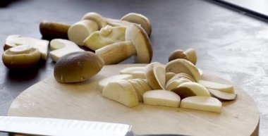 Koyu mutfak masasındaki ahşap kesme tahtasındaki taze kesilmiş mantar mantarını kapat. Yüksek kaliteli FullHD görüntüler