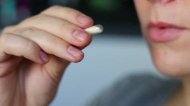 Vitamin kapsülü hapı alan ve granüllerle dolu içme suyu içen bir kadına yaklaş. Sağlık ve refah kavramı. - Evet. Yüksek kaliteli FullHD görüntüler