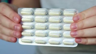 Elinde granülle çözünen vitamin kapsülü haplar olan bir kadının fotoğrafını çek. Sağlık ve refah kavramı. Yüksek kaliteli FullHD görüntüler