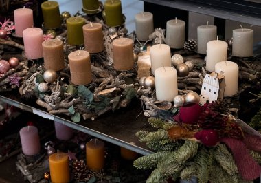 Bir mağazanın rafında mumları olan farklı çelenkler.