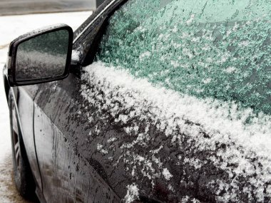 Araba yan aynası, donmuş desenli kar buzu, kış mevsimi ve güvenli sürüş konsepti.