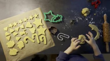 Kısa hamurlu pastadan kurabiye yapan bir çocuğun üst görüntüsü, evde Noel temalı fırın. Yüksek kaliteli FullHD görüntüler
