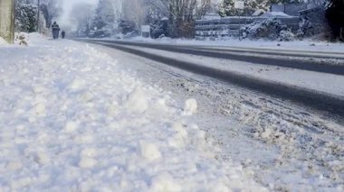 Kış mevsiminde toprak ve araba yolu olan karlı bir cadde.