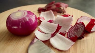 Tahta kesme tahtasındaki kırmızı soğanı bıçakla kapat. Yemek hazırlamak için. Yüksek kaliteli FullHD görüntüler