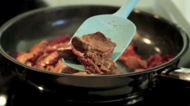 Tavada tavuk ciğerini mavi silikon spatulayla karıştırın, indüksiyon sobası. Yüksek kaliteli FullHD görüntüler