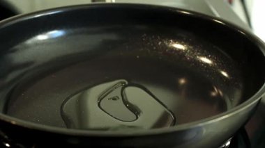 Siyah bir tavaya sebze yağı dök. Yüksek kaliteli FullHD görüntüler