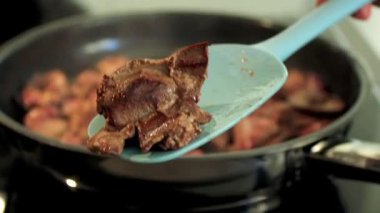 Tavada tavuk ciğerini mavi silikon spatulayla karıştırın, indüksiyon sobası. Yüksek kaliteli FullHD görüntüler