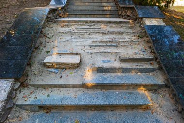 Eski bir taş merdivenin basamakları parçalanıyor ve beton parçalanıyor. Bu bir kamu parkında ya da şehir caddesinde bir altyapı sorunu