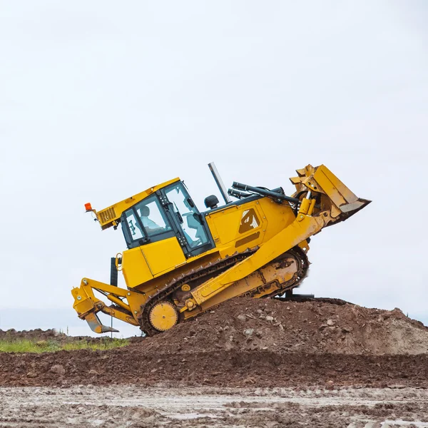 Bulldozer amarelo sujo superar a barreira do solo — Fotografia de Stock