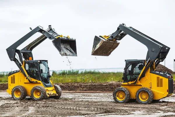 Twee glijders ossen met raiced emmer buitenshuis — Stockfoto