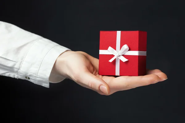 Hand holding box for a gift isolated on black — Stock Photo, Image