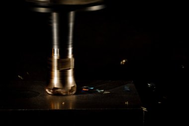 Karanlık bir arka plan üzerinde fırlama parçalanmak ile freze kesici çalışma