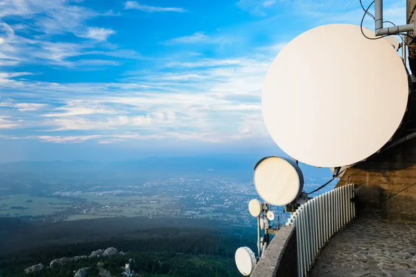 System av telekommunikation antenner högt över landskapet Stockbild