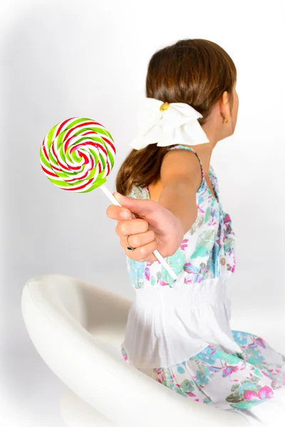 Child - girl refusing sweet lollipop. No sweets! I love my teeth!  focus on rainbow lollipop Stockbild
