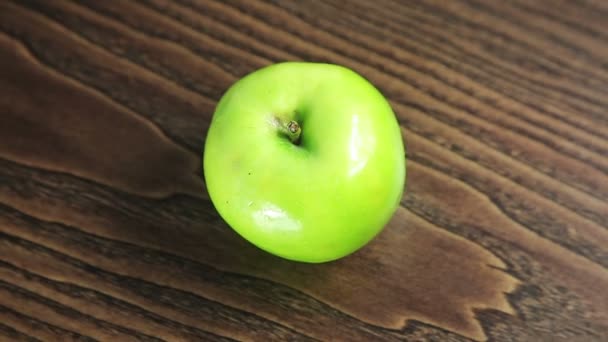 Grüner Apfel auf dem Tisch rotiert — Stockvideo