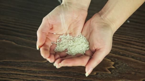 Rijst giet in de handen van een meisje — Stockvideo
