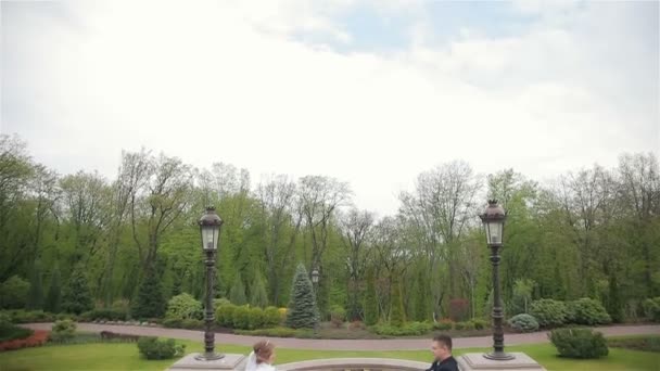 Bruid en bruidegom wandelen in park — Stockvideo