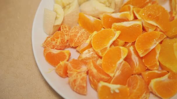 White platter with chopped fruit on wooden table — Stock Video