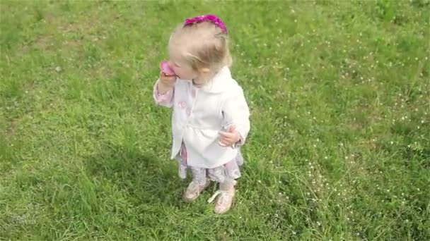 Красивая маленькая девочка ест мороженое — стоковое видео