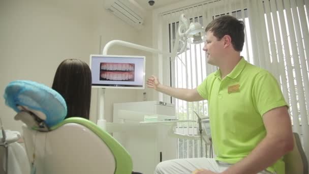 Стоматолог розмовляє з пацієнтом в медичному кабінеті — стокове відео