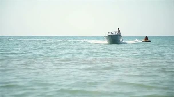 El barco tira de un hombre en el círculo en el mar — Vídeo de stock