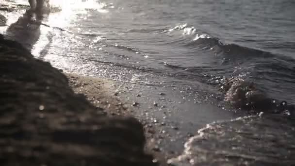 Een man loopt langs de kust. — Stockvideo