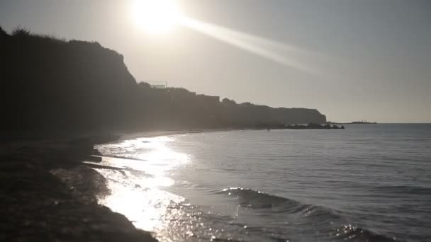 Человек бежит по пляжу на рассвете . — стоковое видео