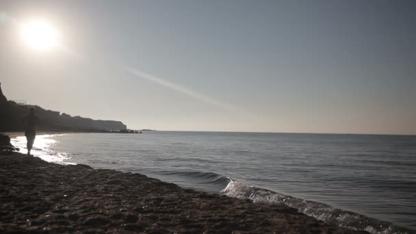 Homem correndo na praia ao nascer do sol . — Vídeo de Stock