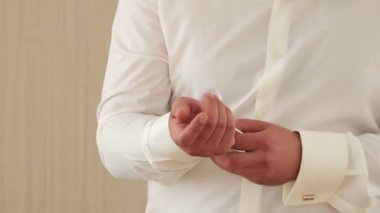 Onun gömlek kelepçeleri damat düğmeleri