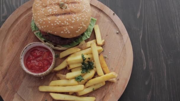 Hamburger, sült krumplival és a mártással, az asztalon — Stock videók