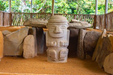 Kolombiya 'nın San Agustin arkeoloji parkında antik taşlarla çevrili taş heykel..
