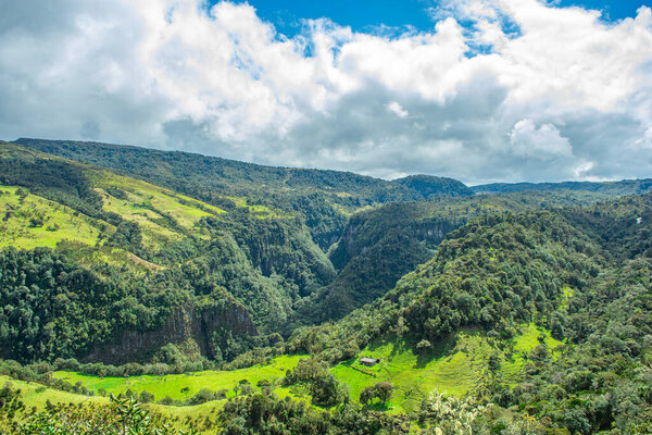 Stunning view of the Andes mountains in Purace, Cauca, Colombia, showcasing lush greenery and dramatic terrain under a vibrant sky.