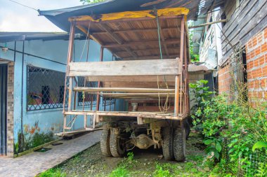 San Cipriano, Buenaventura, Valle del Cauca, Kolombiya 'da yemyeşil bir çevrede park edilmiş ahşap bir yapıya sahip klasik bir kamyon..