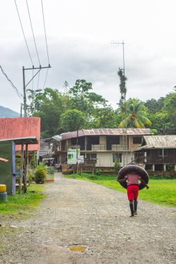 San Cipriano, Buenaventura, Valle del Cauca, Kolombiya 'da, verimli doğa ve kır evleri ile çevrili çakıllı bir yolda yürüyen bir adam..
