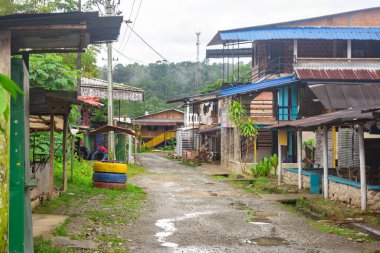 San Cipriano, Buenaventura, Valle del Cauca 'da yemyeşil ve ahşap evlerle çevrili sakin bir kırsal sokak manzarası..