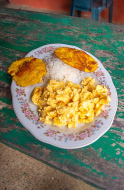 Bir tabak pirinç, çırpılmış yumurta ve kızarmış muz..