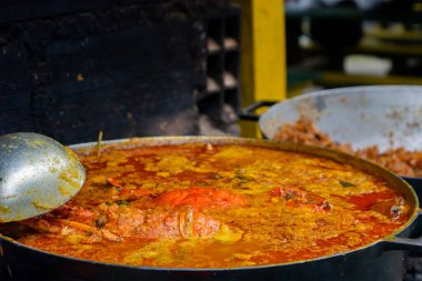 Canlı bir deniz ürünleri güveci büyük bir tencerede pişiyor, taze malzemeler ve zengin renkler içeriyor, Kolombiya mutfağının özünü yakalıyor..