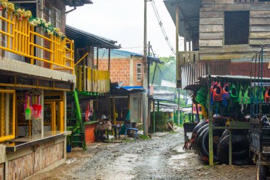 San Cipriano, Buenaventura, Valle del Cauca 'da canlı bir sokak manzarası, yağmurlu bir atmosferin ortasında yerel mimariyi gözler önüne seriyor..