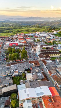 Filandia 'nın hava perspektifi, renkli çatılar ve gün batımında yemyeşil tepeler..