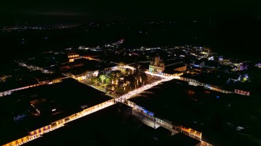 Geceleri Filandia 'nın hava manzarası, aydınlatılmış sokaklar ve dekoratif ışıkları olan tarihi bir bina..