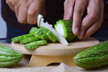 Bir adamın eline yaklaş, yeşil kavunu ahşap bir bıçakla kes..